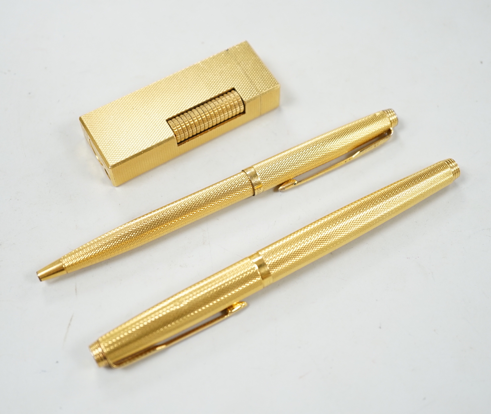 Two gold plated Parker pens together with a Dunhill lighter